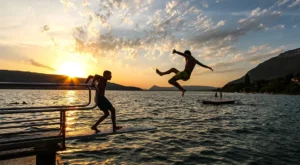Groupe d'adolescents en train de se baigner dans le lac d'annecy au coucher du soleil